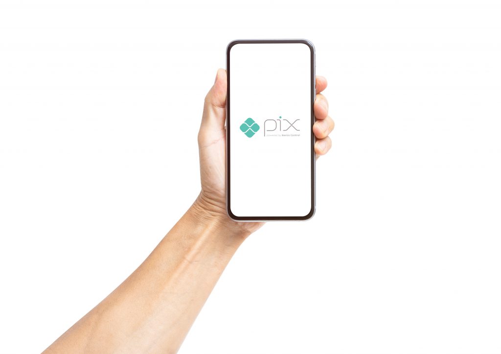 Cliente segurando um celular com imagem do sistema de pagamentos Pix - bug do pix em dobro