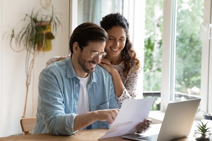 Casal sentado em uma mesa analisando suas finanças