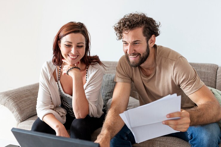 casal sorrindo organizando as finanças